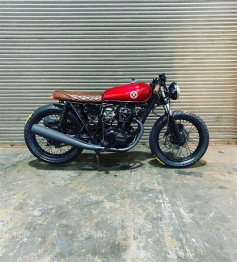 A Red And Black Motorcycle Parked In Front Of A Garage Door