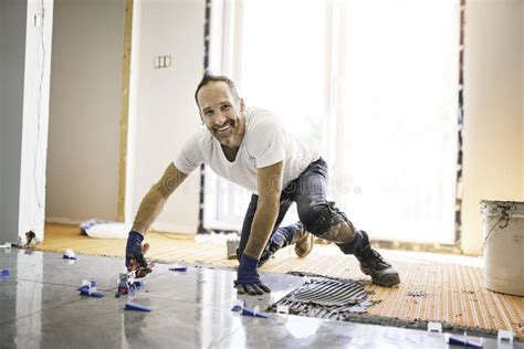 Lindo Hombre De Mano Instalar Azulejos En El Suelo Foto De Archivo