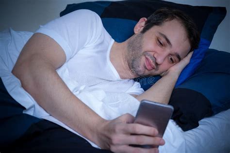 Portrait Of Man Using Mobile Phone In The Bed Stock Image Image Of