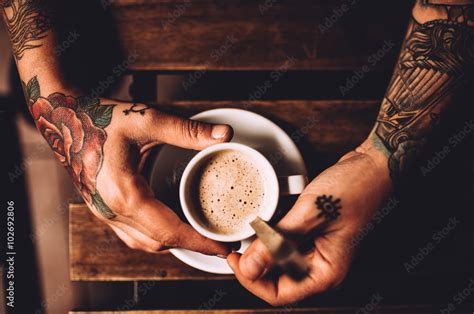 Elevated View Of Man With Tattoo Holding A Cup Of Coffee Stock Photo