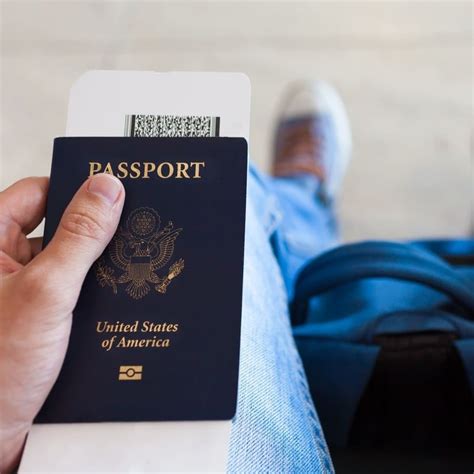 Young Male Traveler Holding Up A Us Passport And A Boarding Card At The