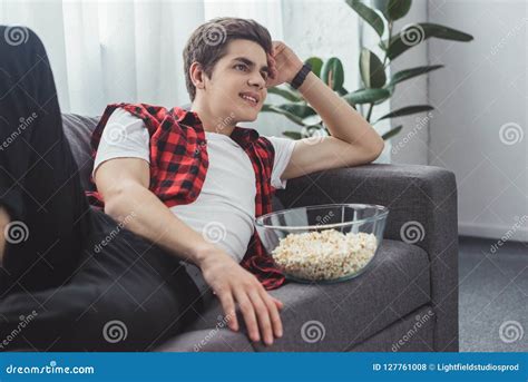 Smiling Male Teenager With Popcorn Watching Movie Stock Photo Image