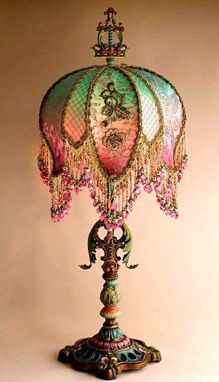 An Ornate Lamp With Pink Flowers On The Bottom And Green Trimmings