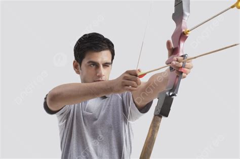 Arquero Masculino Apuntando Con Arco Y Flecha Contra Un Fondo Gris Foto