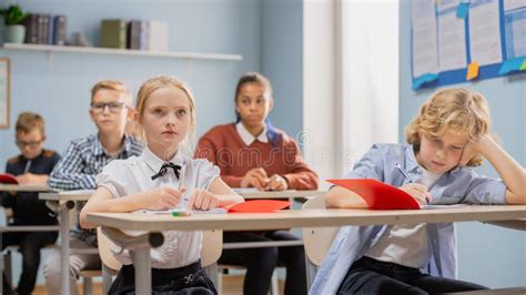 Elementary Classroom of Diverse Children Listening To the Teacher Giving a Lesson. Young Kids in ...