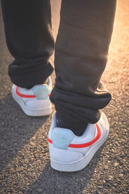 Premium Photo A Person Wearing A White Shoe With A Red Stripe That