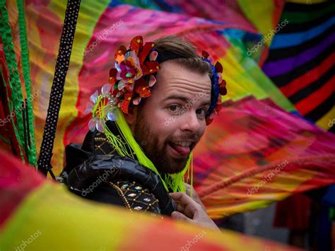 Un joven caucásico en el orgullo gay de París 2022 luciendo barba sacando la lengua mirando a