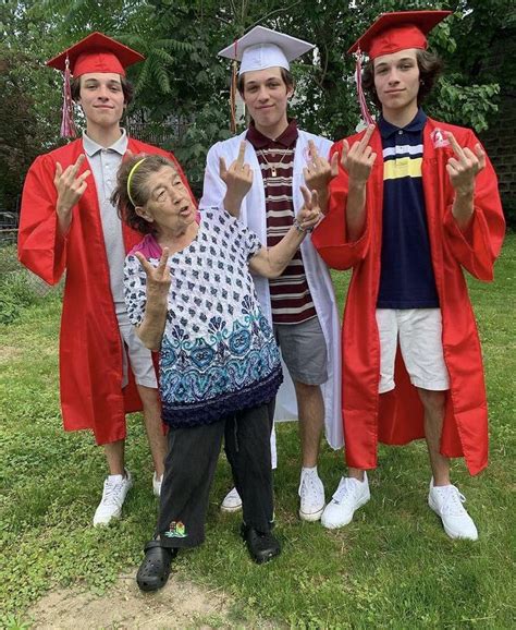 A Group Of People In Graduation Caps And Gowns Posing For The Camera