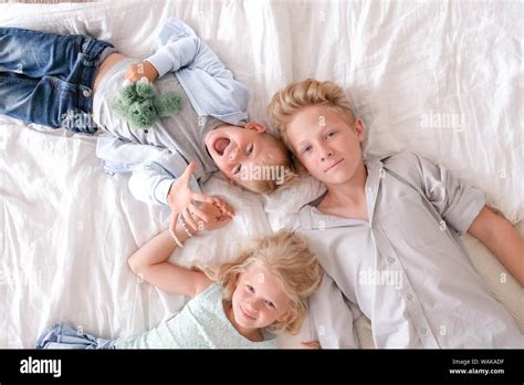 Drei Fr Hliche Blonde Kinder Sind Zusammen Auf Dem Bett Liegend Mit