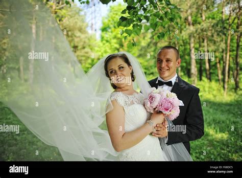 Wedding Couple Under The Tree With Big Bridal Veil Stock Photo Alamy