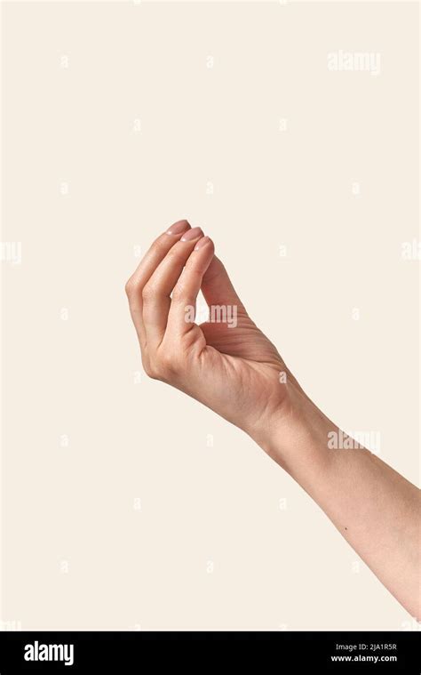 Invisible Object Holding Female Hand On Cream Background Stock Photo