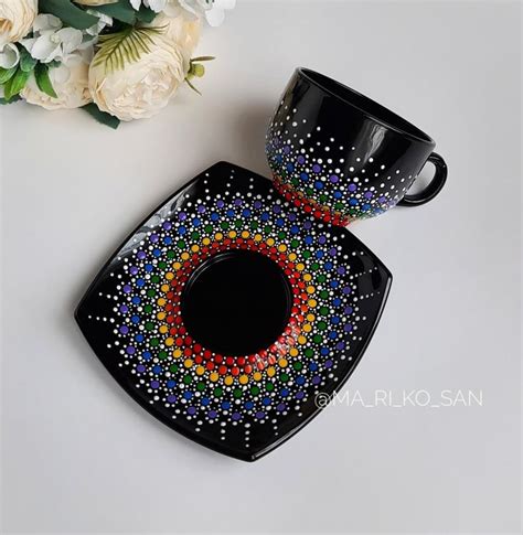 Two Black Coffee Mugs Sitting Next To Each Other On Top Of A White Table