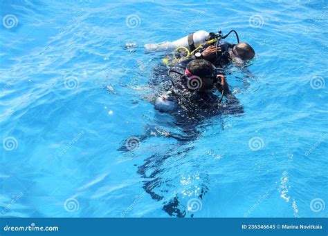 Learning Process Of Scuba Diving Experienced Instructor Teaches Beginner To Dive Into Sea Using