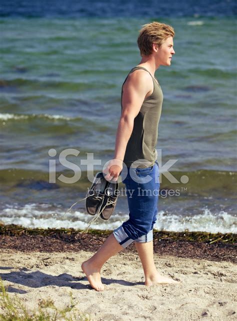 Handsome Man Walking Alone On The Beach Stock Photo | Royalty-Free ...