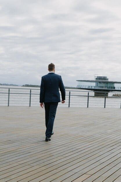 Premium Photo Rear View Of Man Standing On Pier Over Sea Against Sky