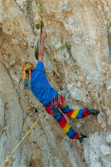 Sport Rock Climber Man With Colorful Hair On Challenging Overhanging