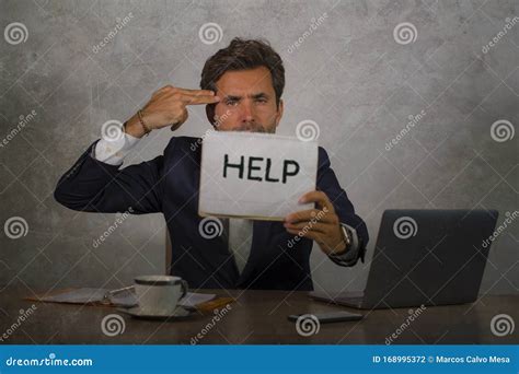 Depressed And Stressed Attractive Hispanic Man In Suit And Tie Working