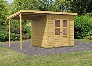 a small wooden shed sitting on top of a grass covered field