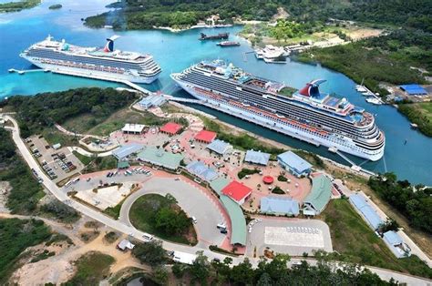 Two Cruise Ships Docked In The Water Next To An Island With Several