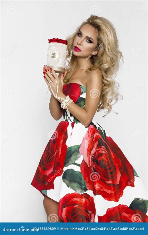 Beautiful Blonde Woman In An Elegant Evening Gown With Red Roses