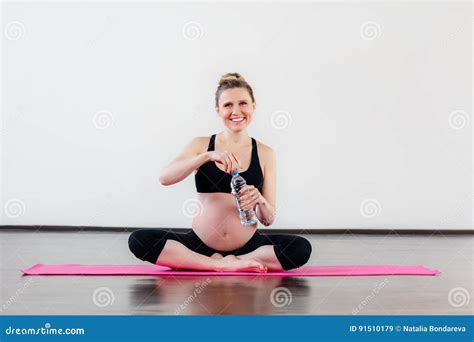 Femme Enceinte De Sourire S Asseyant En Position De Lotos Dans La