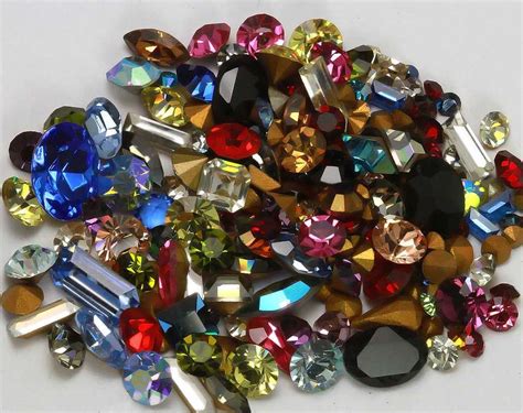 A Pile Of Assorted Colored Jewel Stones On A White Surface With Clippings