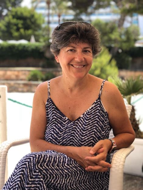 Premium Photo Portrait Of Smiling Mature Woman Sitting On Chair