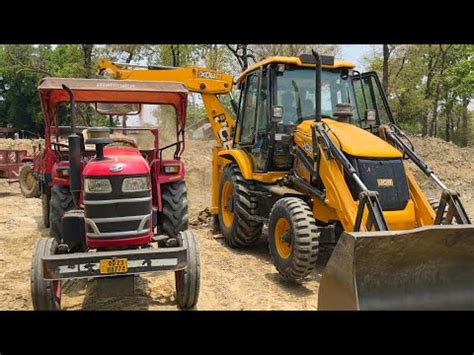 Jcb Backhoe Machine Loading Mud In Mahindra YUVO And Swaraj Tractors