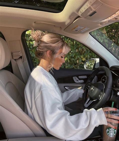 A Woman Sitting In The Driver S Seat Of A Car