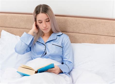 Free Photo Young Beautiful Woman In Blue Pajamas Sitting On Bed