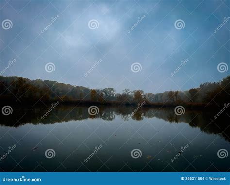Scenic View Of A Calm Lake With A Reflection On Trees And Sunset Sky On