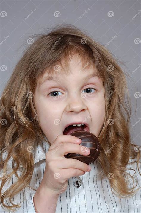 A Little Girl Biting Chocolate Coated Cookie Stock Photo Image Of