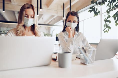 Deux collègues féminines travaillant ensemble au bureau portant des