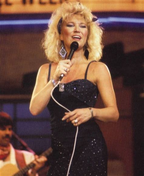 A Woman Singing Into A Microphone On Stage