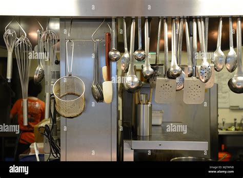 Cooking utensils hanging up in a kitchen in a large restaurant Stock Photo - Alamy