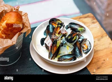 Moules Aux Oignons Et Lardons à La Crème Dans Une Assiette Avec Du Pain