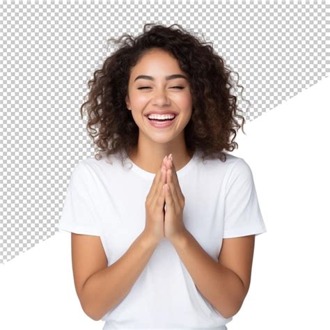 Una mujer con una camisa blanca está sonriendo con las manos juntas