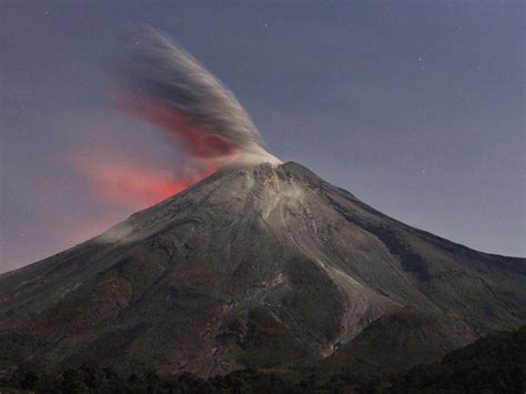 A Very Tall Mountain With A Red Cloud Coming Out Of It S Top And The