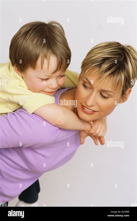 Mother Giving Son Piggyback Ride Stock Photo Alamy