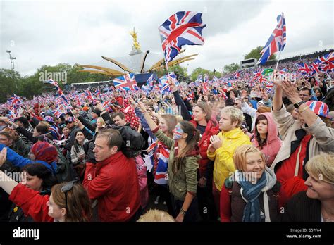 Crowds In Front Of Buckingham Palace In London Wave Flags As Queen