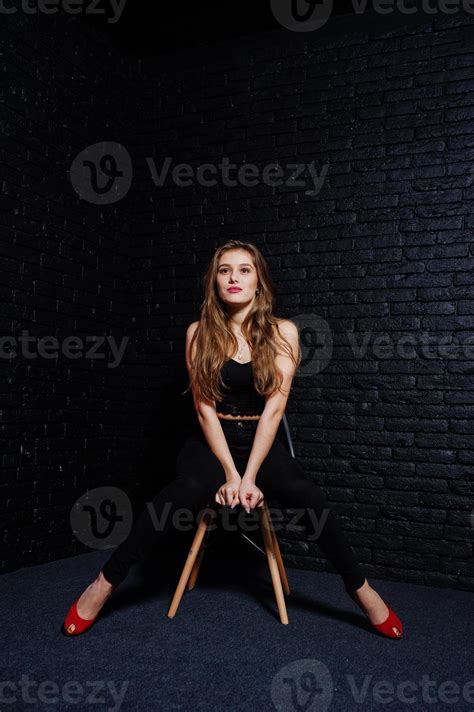 Handsome Brunette Girl Wear On Black And Red High Heels Sitting And Posing On Chair At Studio