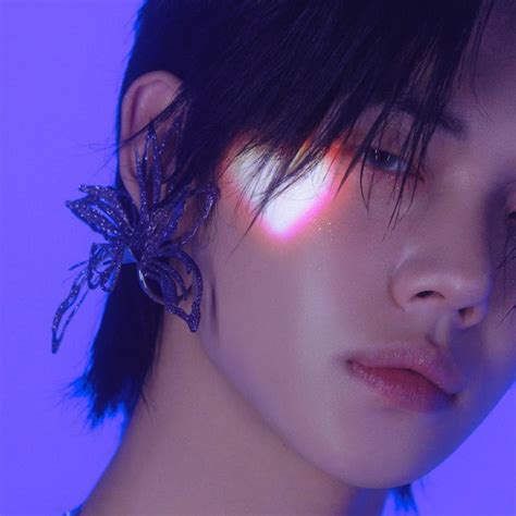 A Close Up Of A Person With Dark Hair And A Purple Light Behind Her Head