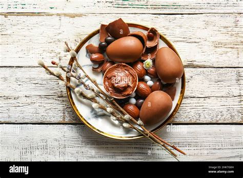 Plate With Chocolate Easter Eggs And Pussy Willow Branches On Light Wooden Background Stock