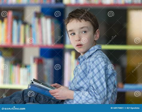 Cute Boy Reading Book In Library Stock Image Image Of Bookshelves