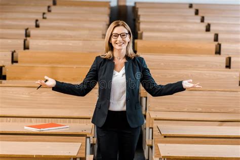 Female University Professor In Formal Wear Standing Near Chalkboard