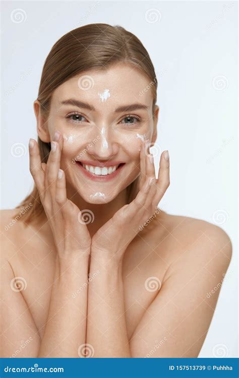 Skin Care Woman Applying Facial Cream On Beauty Face Closeup Stock