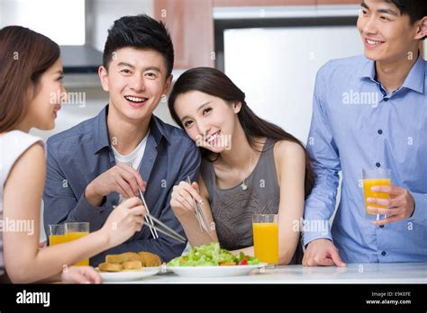 Happy friends eating together Stock Photo - Alamy