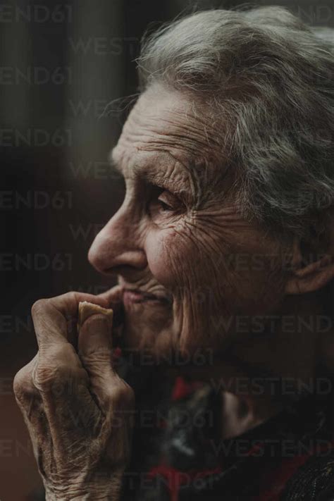 Side View Of Thoughtful Elderly Woman With Gray Hair Touching Wrinkled