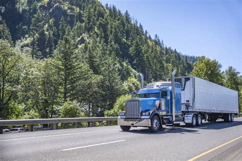 Powerful Blue Big Rig Long Haul Semi Truck Transporting Frozen Cargo In