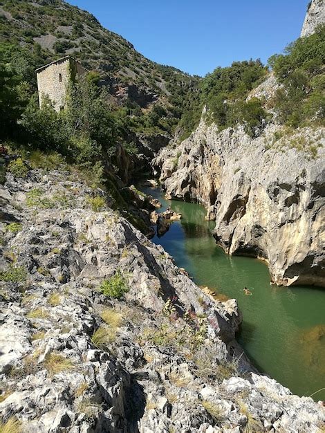 Premium Photo River Amidst Rocky Mountains On Sunny Day